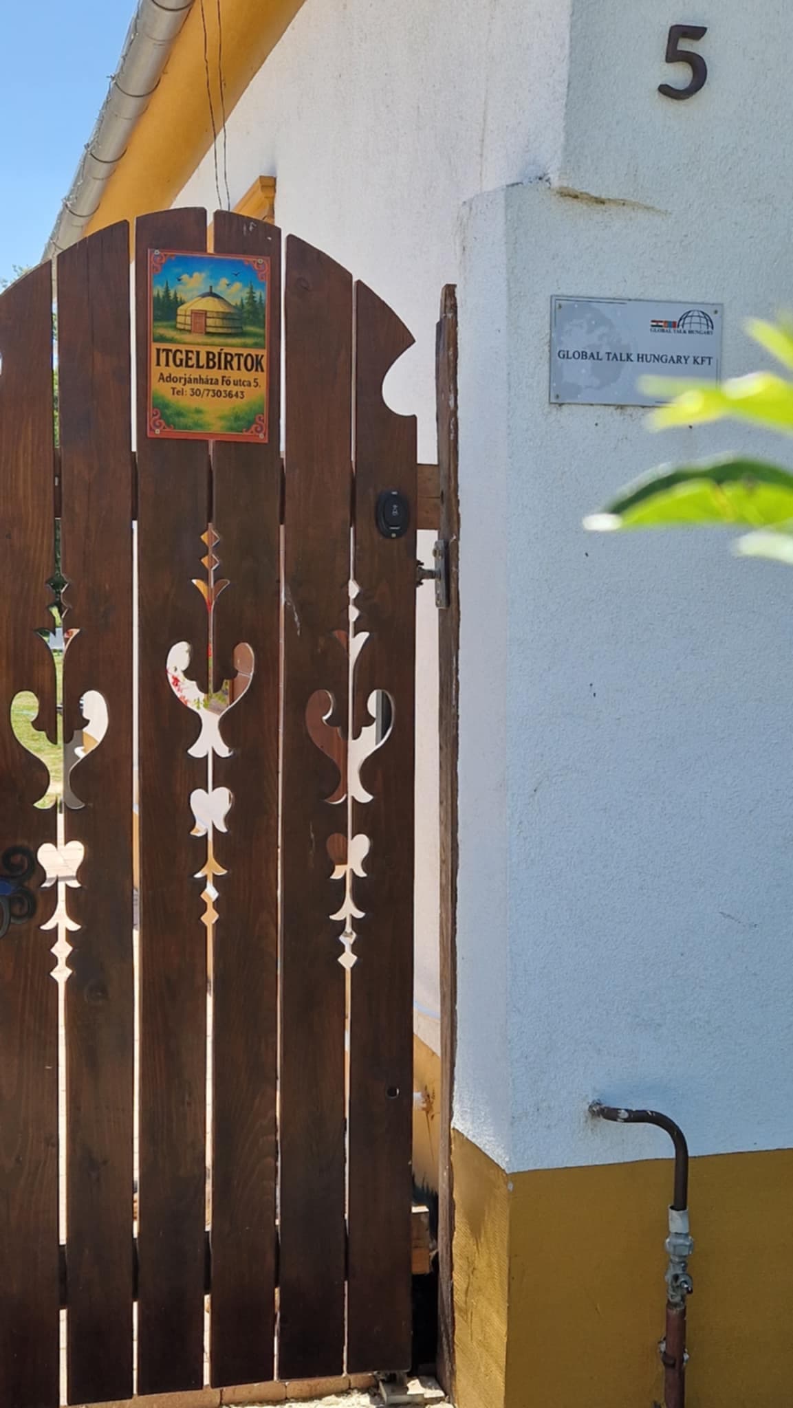 Itgelbirtok – Faragott fa bejárati kapu Itgelbirtok táblával